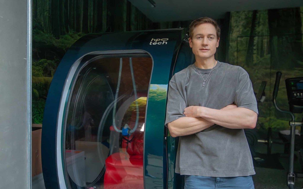 Bryan Johnson stojí vedle hyperbarické komory používané pro wellness a regeneraci